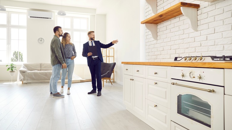 realtor showing couple white kitchen