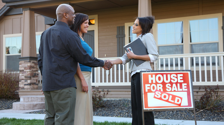 realtor and couple outside home