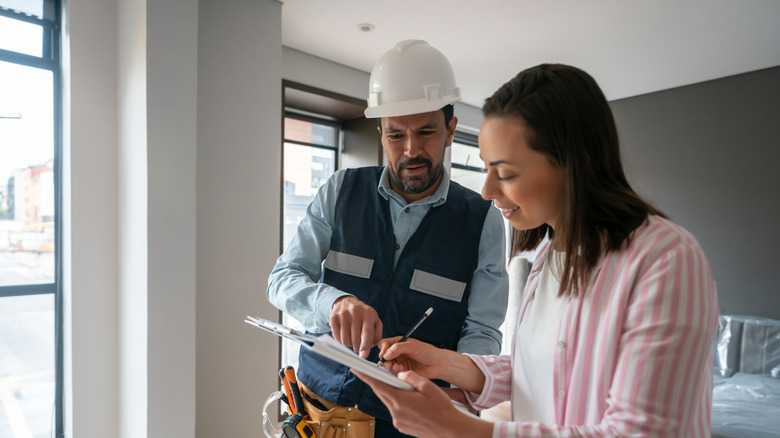 Homeowner talking to contractor about paperwork