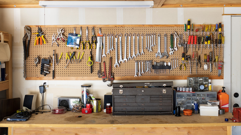 An array of tools displayed on a peg board in a workshop.
