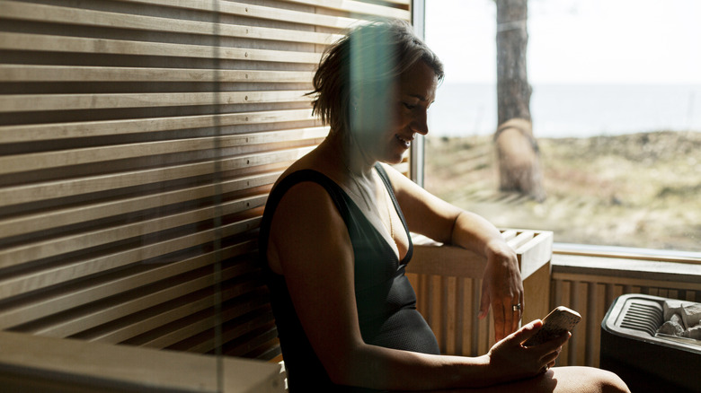 A woman on her phone in a mobile sauna.