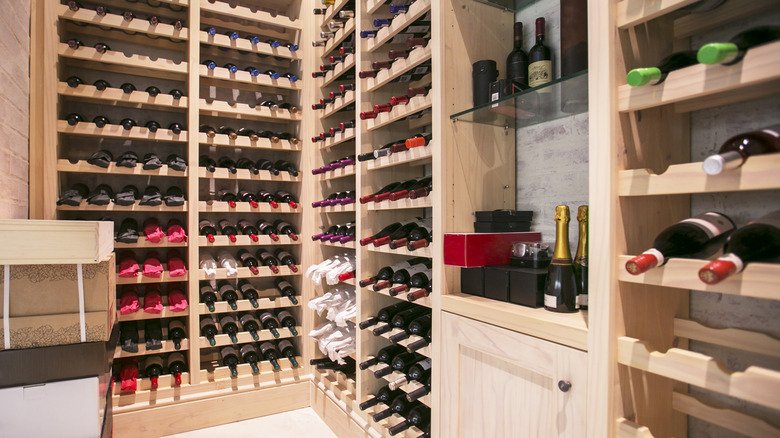A home wine cellar with vertical shelving and glass shelving.