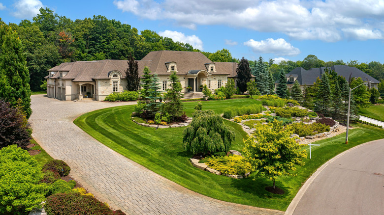 A house on a hill with beautiful landscaping in the front yard.
