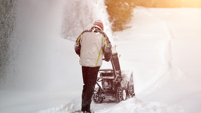 A person using a snowblower