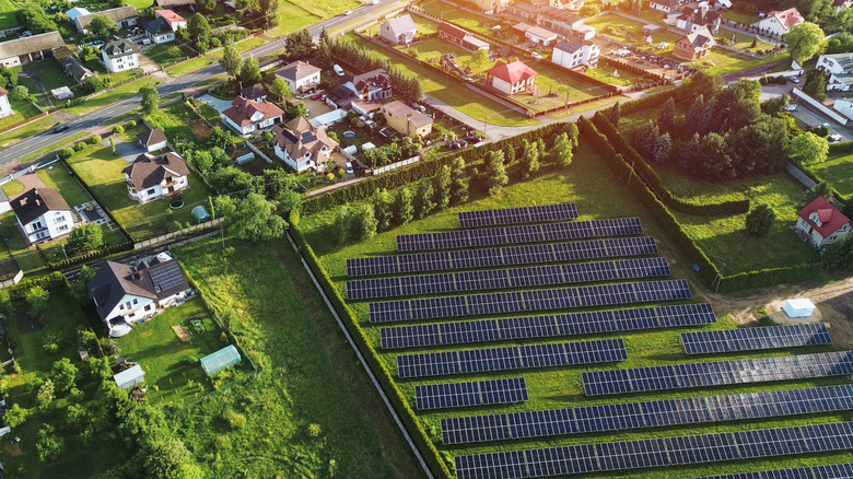 Rows of solar panels surrounded by a neighborhood of single family homes.