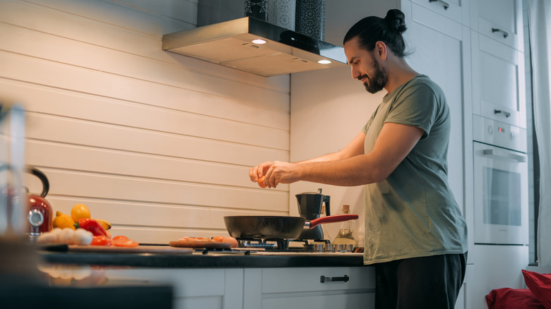 Man cooking over range