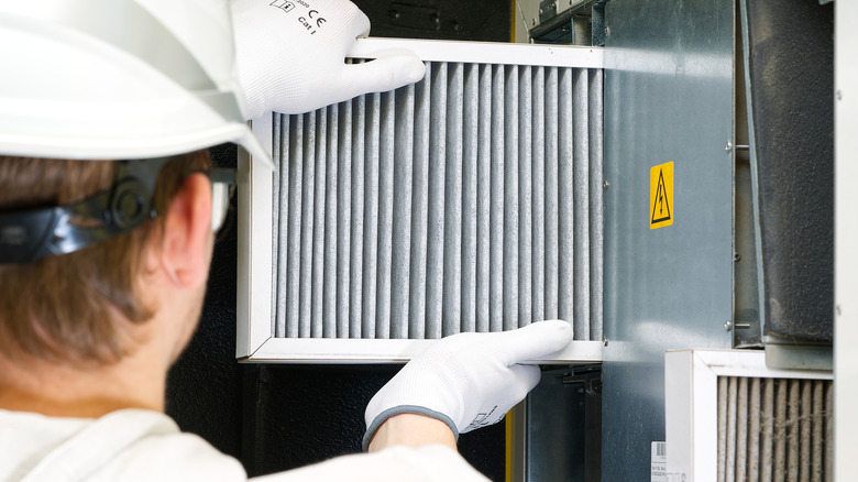 Technician installing a clean filter in the HVAC system