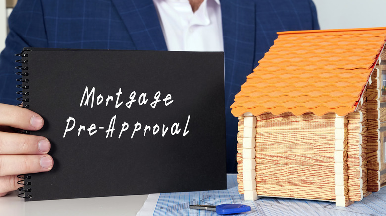 Person holding mortgage pre-approval sign