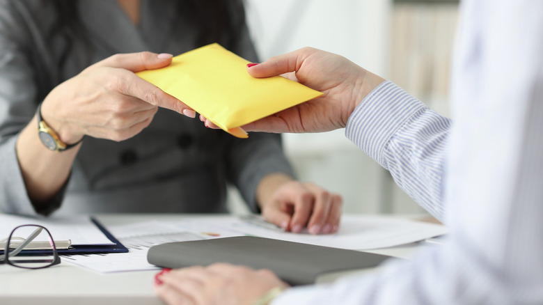 women exchanging full envelope