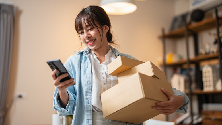 Happy person holding boxes of online shopping purchases