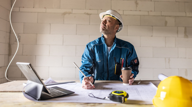 A contractor drawing up a plan for a roof