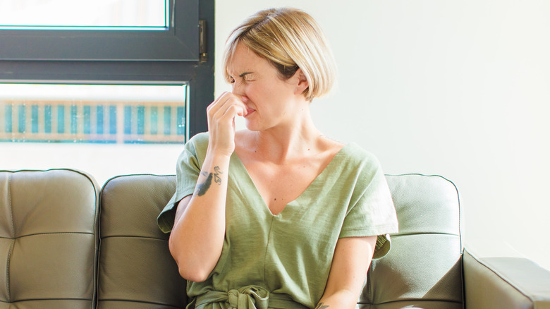 Woman plugging her nose