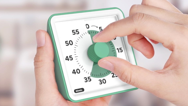 A person sets a kitchen timer before starting a decluttering session.
