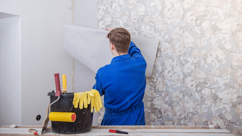 Person hanging up wallpaper