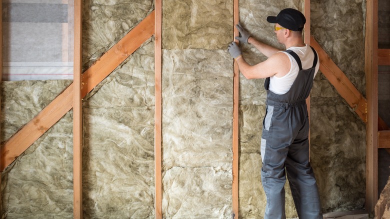 A man installing insulation in the walls.