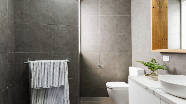 A bathroom with large gray square tiles