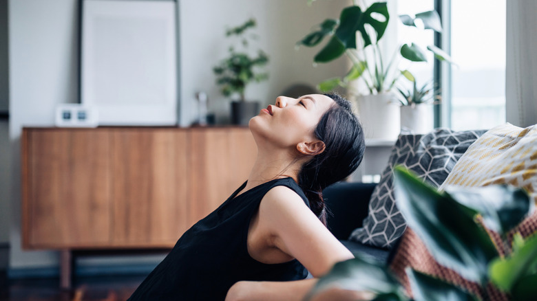 A young woman relaxes in a peaceful room filled with comforting elements.