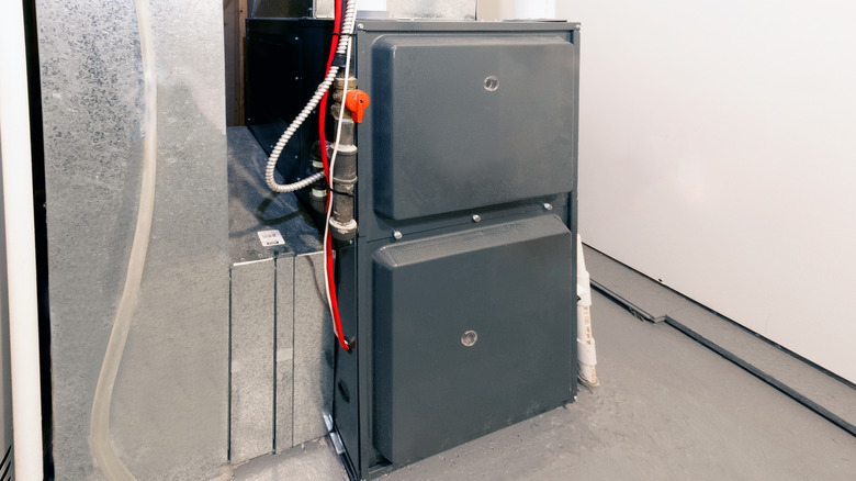 A newly installed high-efficiency furnace sits on a clean concrete floor in a sealed area.