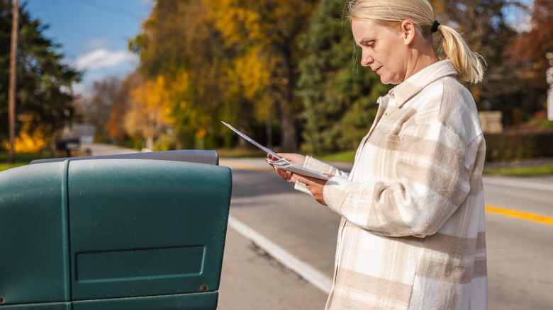 Woman checking the mail next to her mailbox