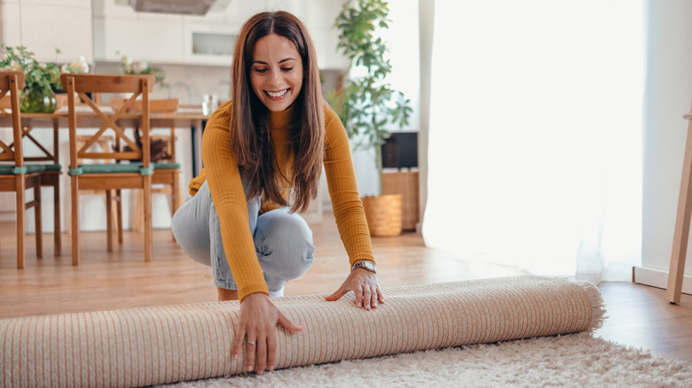 person rolling out area rug