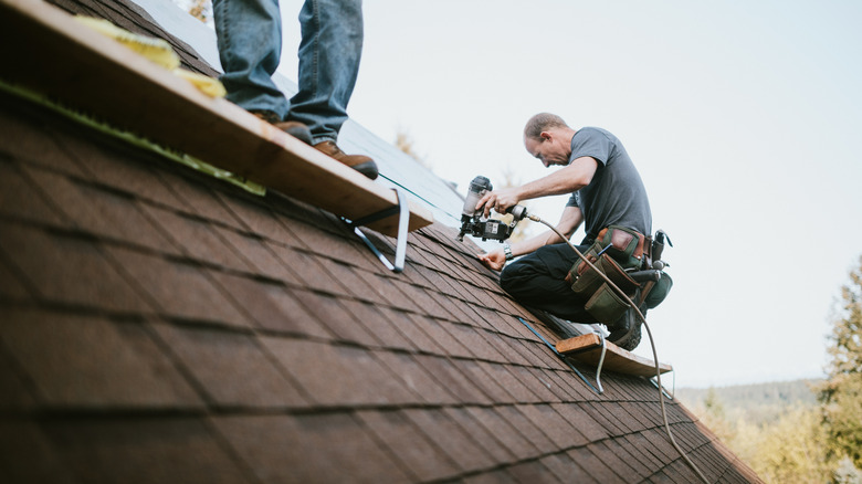 Roofer repairing a shingle roof