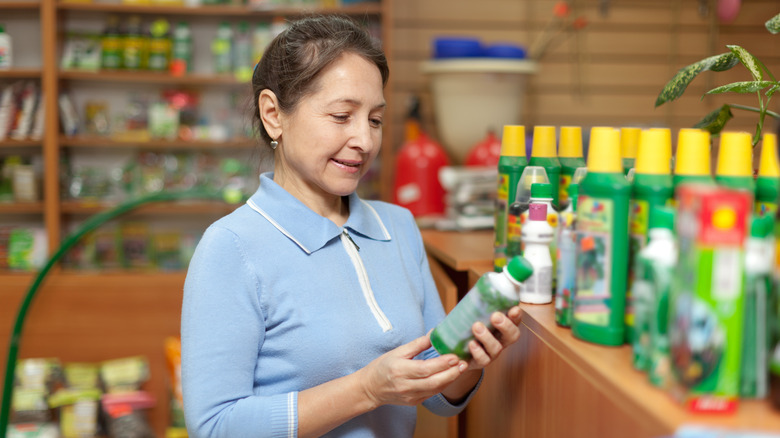 A person shopping for houseplant fertilizer