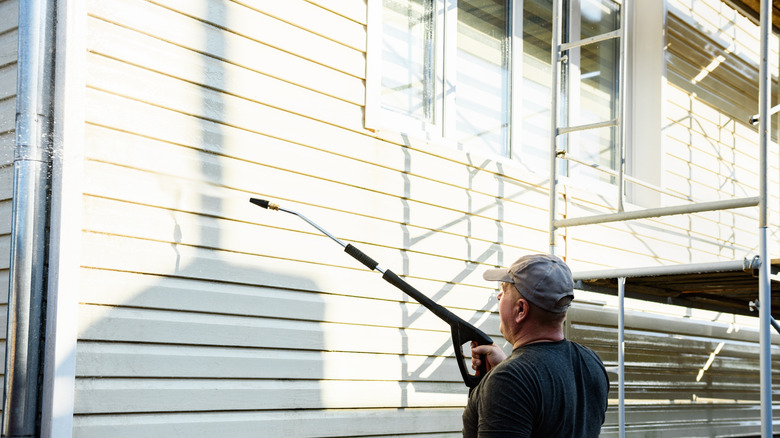 Pressure washing a vinyl siding house