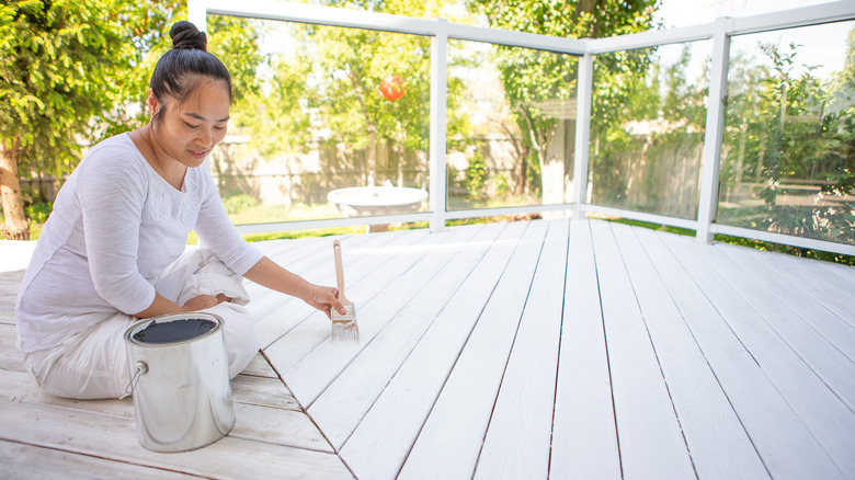 woman painting a deck