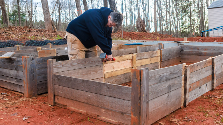 Person assembling raised wooden garden beds