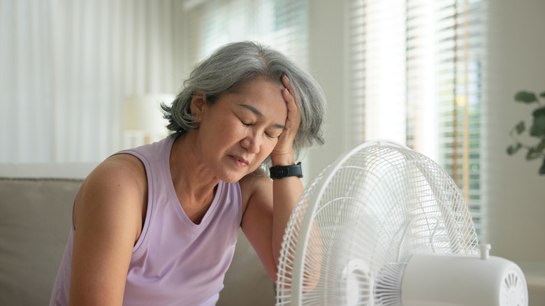 Woman sitting in front of a fan to keep cool