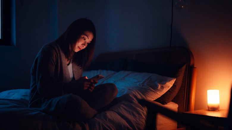 Woman looking at her phone in a dark room