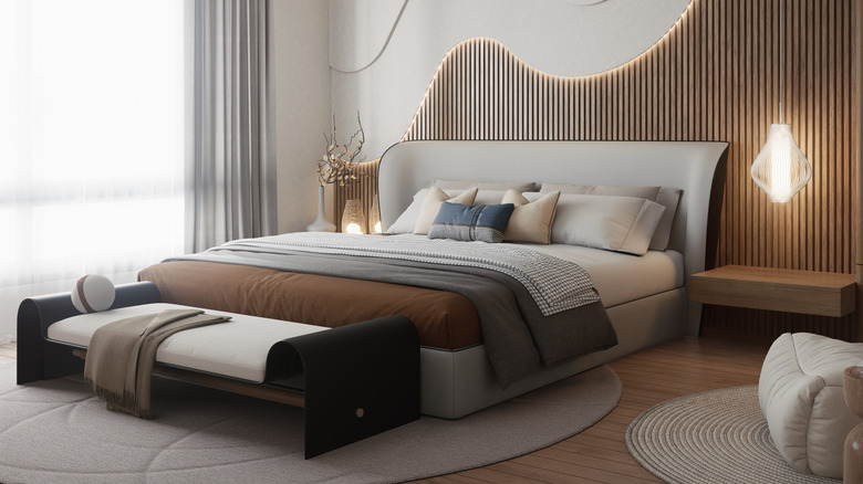 A bedroom with a fully made bed, including layered blankets and multiple throw pillows