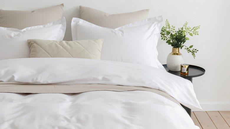 Bed dressed with fluffy pillows and duvet cover