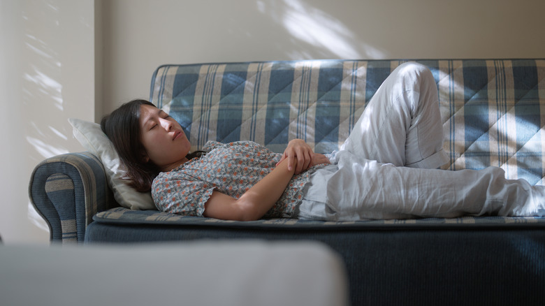 Woman sleeping on sunny sofa