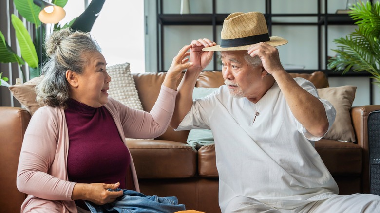 senior couple packing and wearing hat