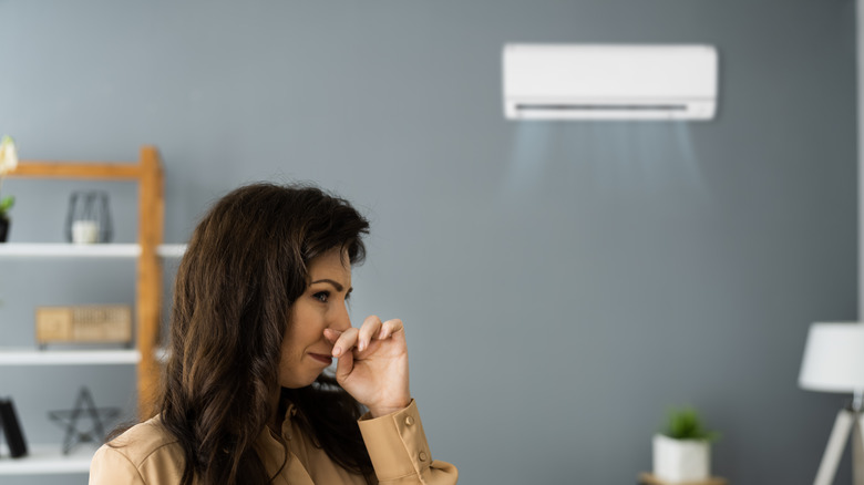 Woman blocking nose from odor 