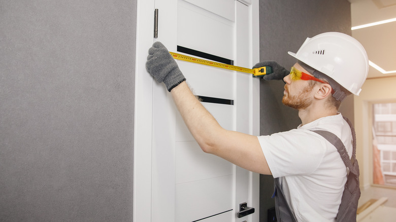 contractor measuring door for proper fit