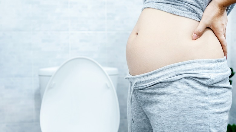 pregnant woman next to toilet