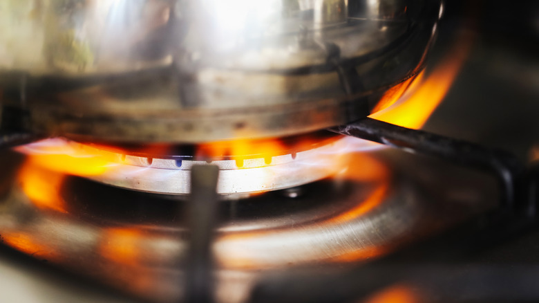 Pot on a gas stove with an orange flame