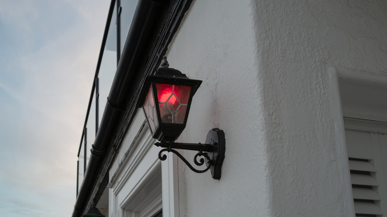 Home with a red bulb in an outdoor lantern