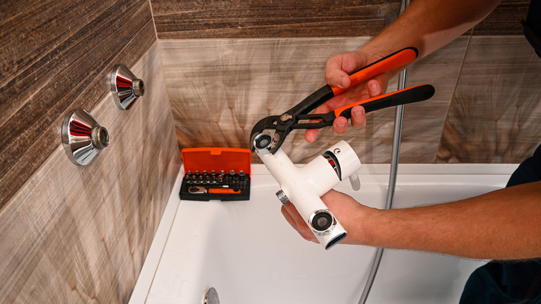Plumber repairing bathtub