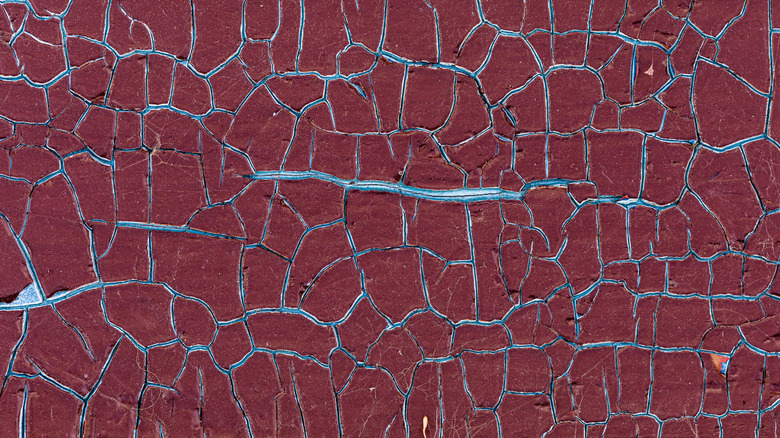 Dark-red paint has deteriorated over time to create an 'alligator' effect