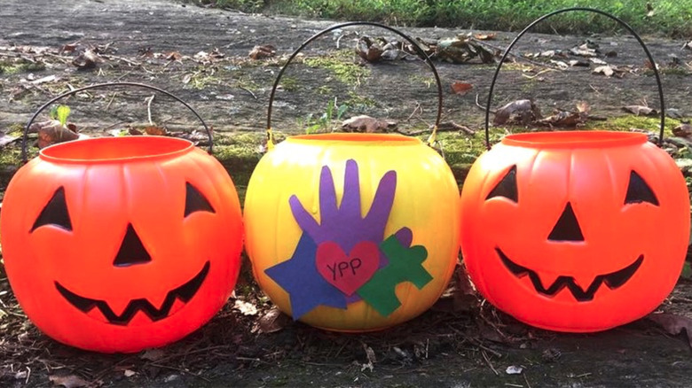 Pumpkin-shaped buckets, with a Yellow Pumpkin Parade bucket in the middle