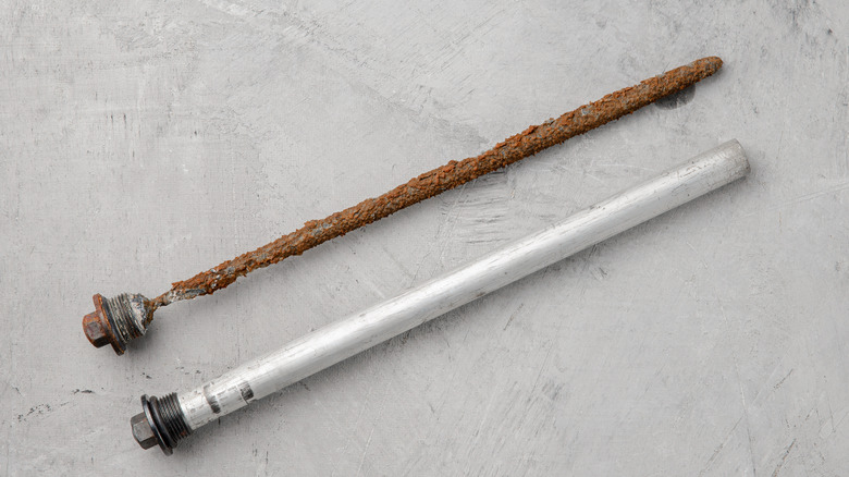 Close up of new anode rod and old corroded anode rod