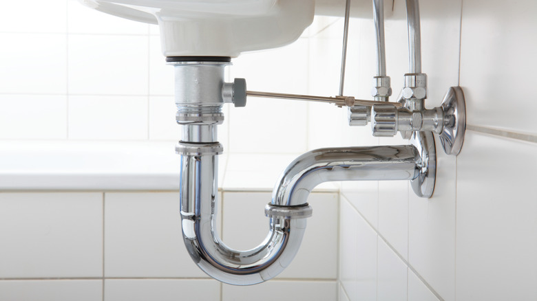 Close up of P-trap or U-bend pipe underneath bathroom sink