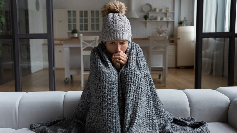 Person warming hands on couch