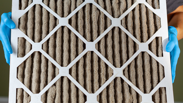 Person holding clogged HVAC filter