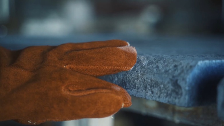 gloved hand on flamed granite