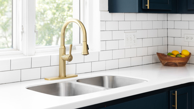 quartz countertop in modern kitchen with gold sink faucet