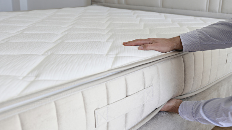 Man testing firmness of luxury mattress